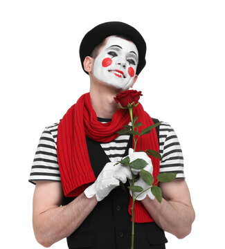 Funny mime artist with red rose on white background