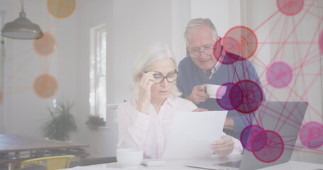 Image of media icons over senior caucasian couple using laptop