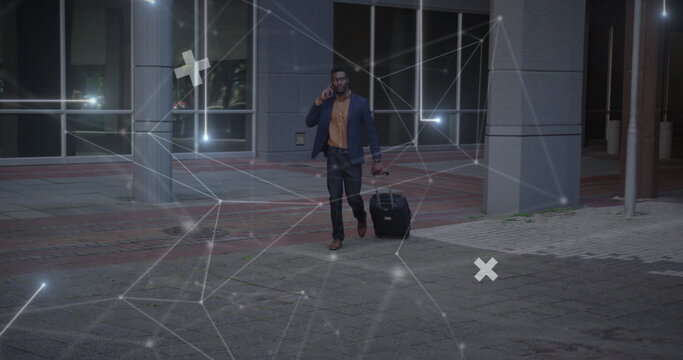 Image of network of connections over african amercian businessman with suitcase