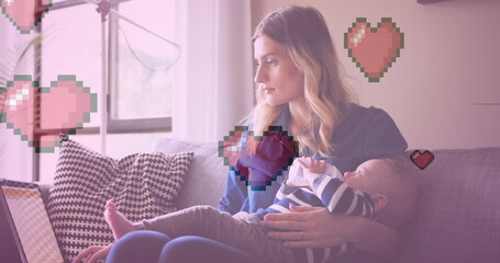 Image of heart icons over caucasian mother holding baby