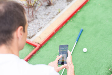 Touch screen in hand, tablet on golf club. smartphone with a sports betting application - 792740058