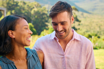 Portrait Of Laughing And Smiling Multi-Racial Couple Standing Outdoors In Countryside