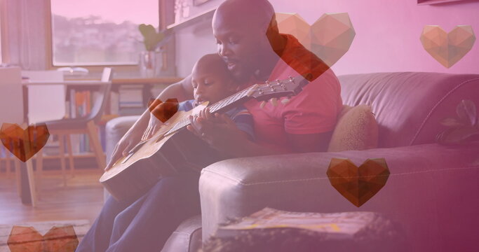 Image of heart icons over african american father with child playing guitar