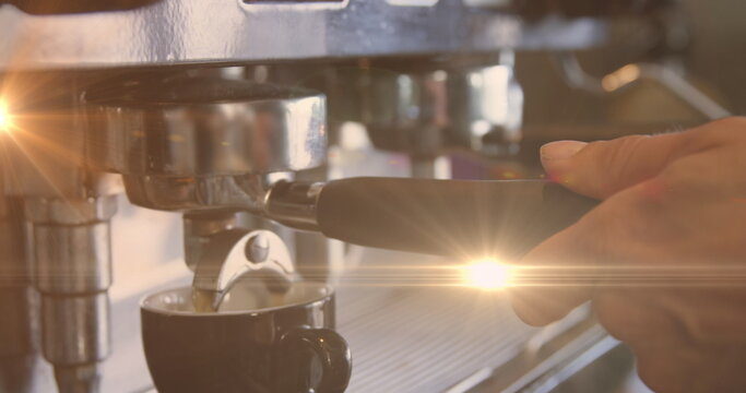 Fototapeta Image of glowing orange light over caucasian male barista making coffee
