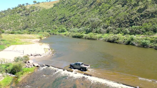 Drone footage of a ute driving through the Murrumbidgee River at Angle Crossing in the Australian Capital Territory.