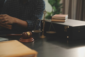 Justice and Law concept. Legal counsel presents to the client a signed contract with gavel and legal law or legal having team meeting at law firm in background