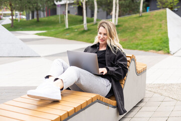 Young woman with laptop outside - 792743620