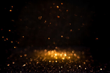 Warm golden bokeh lights illuminate a dark backdrop, creating an abstract pattern of soft glowing orbs ideal for backgrounds. Blurred shine bokeh for overlay effect.