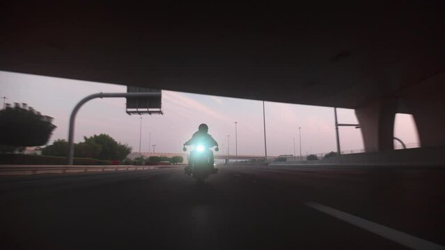 A Roller Shot of a black motorcycle cruising around the city of abu dhabi, A badass motorcycle rider riding around the city of abu dhabi, united arab emirates