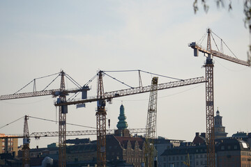 Fototapeta premium Low angle view of cranes above the city