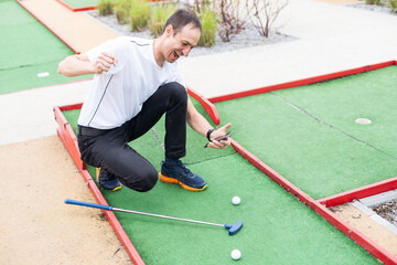 player looks at his hit on a mini golf course - 792754485