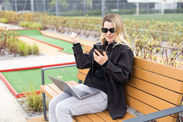 woman on golf course with smartphone with sports betting app - 792756078