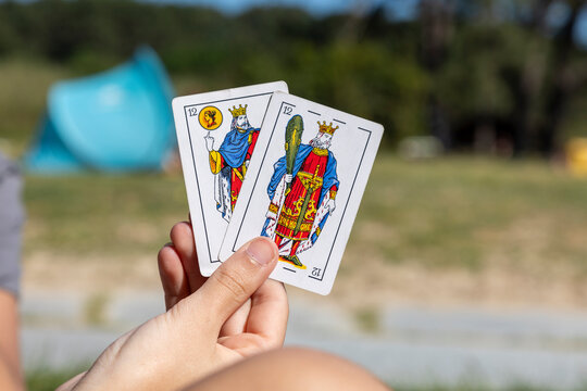 Close-up of a hand with cards from the Spanish deck, with different cards