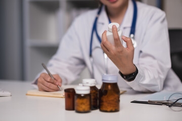 A woman doctor is holding a bottle of medicine in her hand