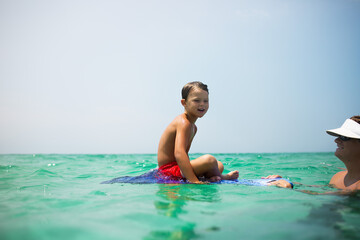 Child learning to boogie board in the ocean