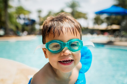 Smiling child in goggles ready for poolside fun