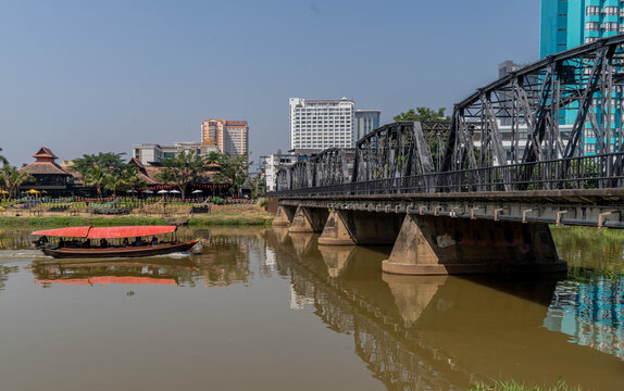 Tourist boat sailing by the Victorian era Iron Bridge in Chiang Mai,Thailand