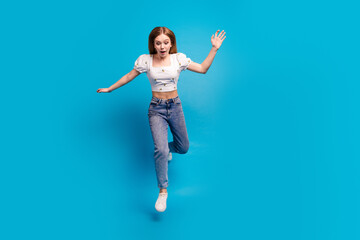 Fototapeta na wymiar Full size photo of nice young girl jump fall empty space wear top isolated on blue color background