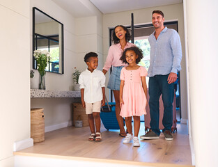 Excited Multi Racial Family With Luggage Arriving In House Or Apartment For Summer Vacation
