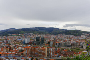 panorama of the city of bilbao with cloudy sky and mountains with modern big business tower