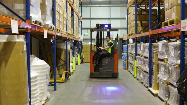 worker driving electric forklift inside a warehouse , Logistic distribution industrial interior