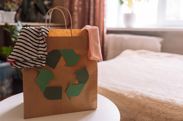 Paper bag with recycling sign with old clothes.