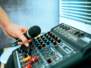 Hand Sound engineer  holding microphone on sound mixer in live broadcasting studio producer for...