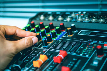 Close-up of sound engineer hands adjusting control sound mixer in recording, broadcasting...