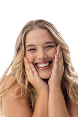 A young Caucasian plus size model laughs, touching her face on white background