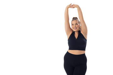 A Caucasian plus size model on white background stretches her arms up, copy space