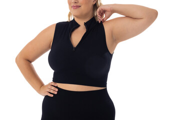 Caucasian plus-size young woman in black sportswear poses confidently on white bg - 792789442