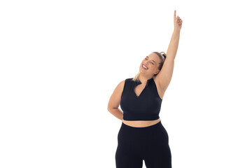 Caucasian plus-size young woman in black sportswear on white, pointing up - 792789463