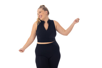 Caucasian plus-size woman in black activewear dances on white background