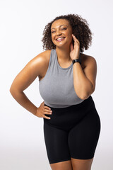 Biracial plus-size young female model laughs, touching her face; white background - 792789607