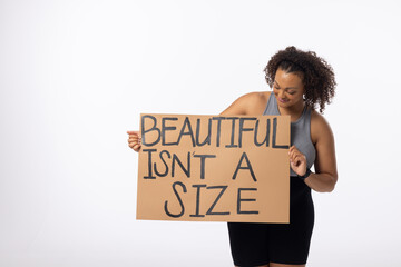 Biracial young female plus size model holds poster on a white background