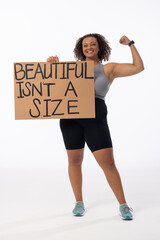 Biracial plus-size model flexes, holds poster on white background - 792789697