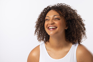 A biracial young female plus size model laughs on white background, copy space - 792789801
