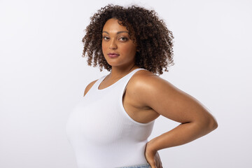 A biracial young female plus size model poses on white background, copy space - 792789814