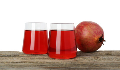Refreshing pomegranate juice in glasses and fruit on wooden table against white background