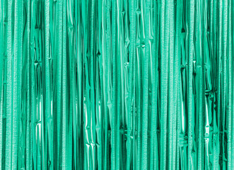 Green turquoise foil strip background. Curtain hanging on wall. Festive, Christmas, New Year or...