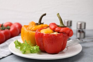 Delicious stuffed peppers with egg on grey table, closeup