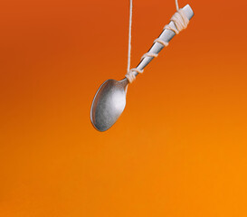 Levitating spoon on orange background