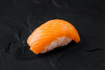 Fresh salmon nigiri sushi on black slate