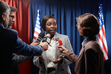 Young African American woman explaining political issues while answering questions of journalists...