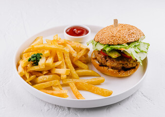 Classic burger and fries on white plate with ketchup