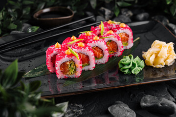 Vibrant sushi roll platter on dark stone background