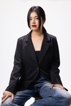 Young sexy fashionable Asian woman wearing black jacket shows perfect red lips in studio. Cosmetics, femininity.