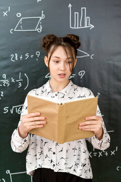 Emotional girl schoolgirl with open book in her hands.