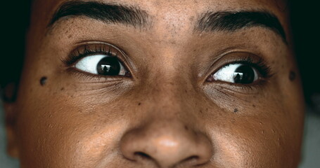 One Horrified Young Black Woman in Macro Close-Up, Eyes Wide Open in Shock looking sideways, Expressing Fear and Paranoia