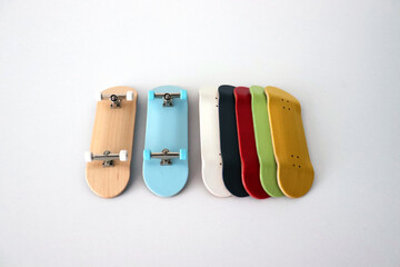 Blank wooden handmade fingerboards with the different type colour of wood texture on white background. Mini skateboard, small skateboard deck © Tom